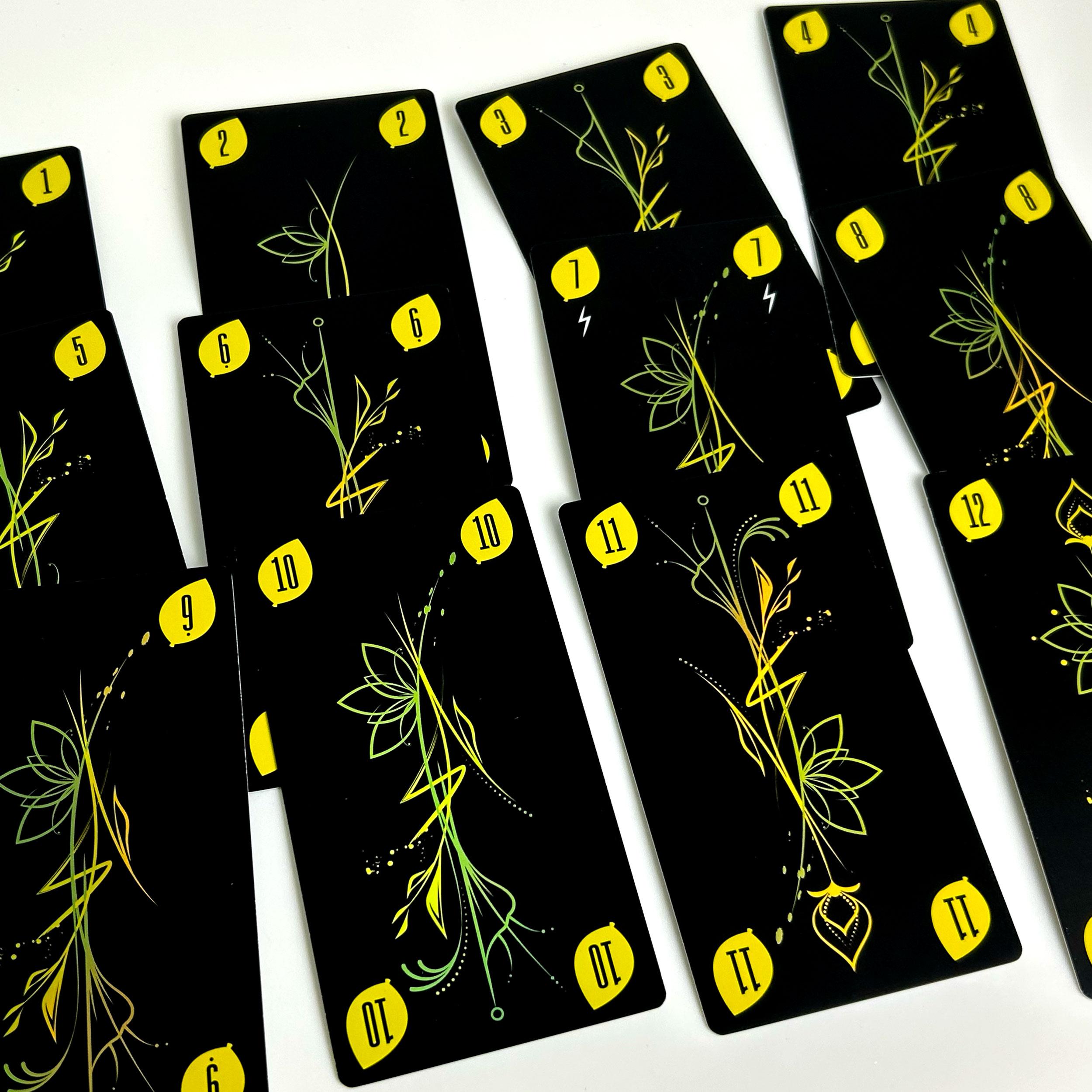 Yellow suit number cards laid out, showing values from 1 to 12 with a plant-inspired graphic design.